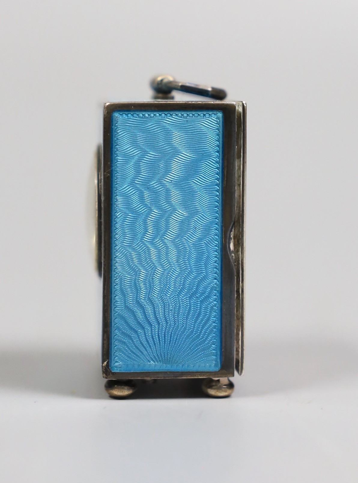 A George V Swiss blue enamel and silver cased miniature carriage timepiece, import marks for Arthur George Rendell, London, 1924, 43mm, on bun feet, in gilt tooled leather carrying case